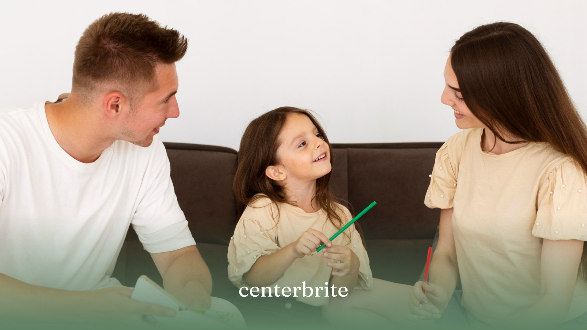 A family of three sitting on a couch
