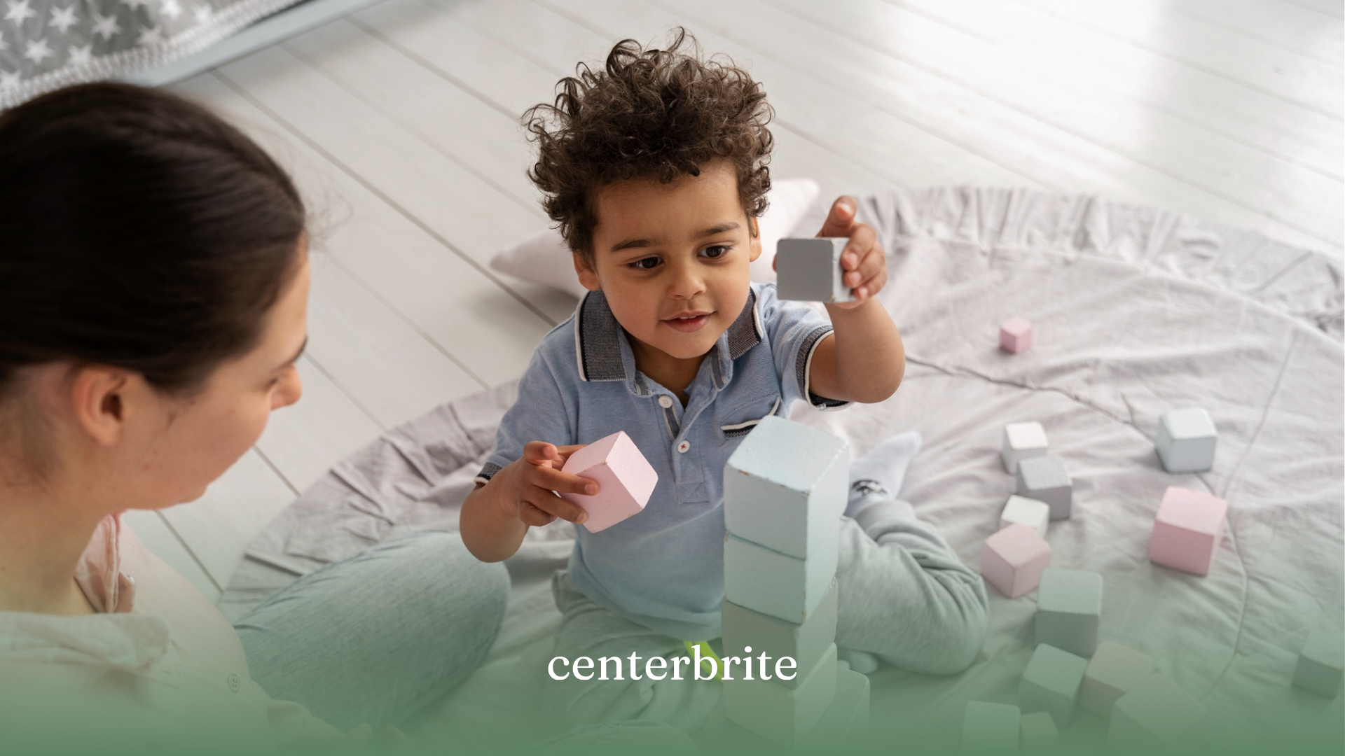 A kid with autism playing with building blocks with his BCBA during ABA therapy